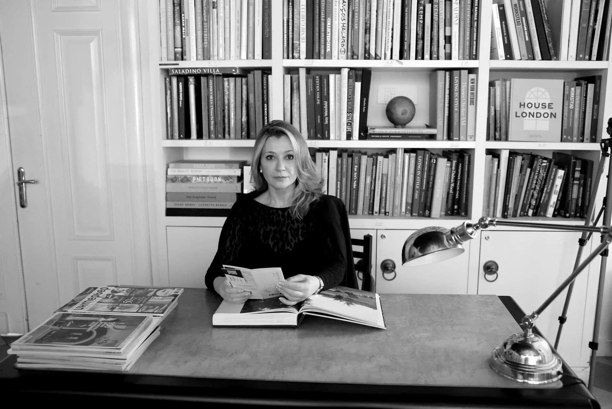 L’architetto e designer Natalia Enze seduta alla scrivania davanti a una biblioteca